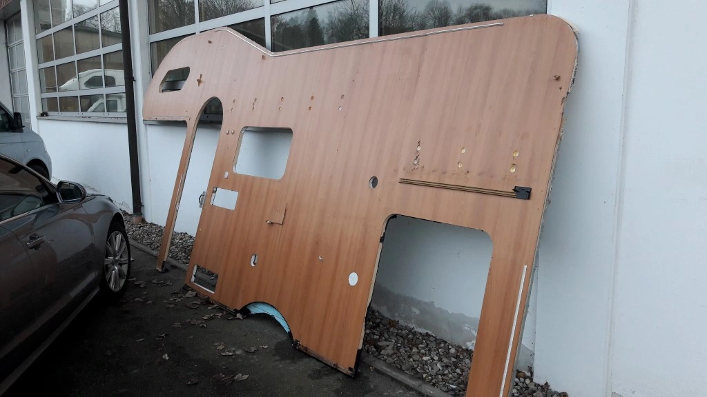Wohnwagen Gutachter Wöllenweber fotografiert den Schaden an der ausgebauten Wohnwagen Seitenwand
