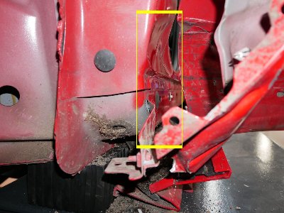 Roter Ford Kuga mit sichtbaren Schrammen und deformierter linker Fahrzeugflanke nach einem Seitenaufprall