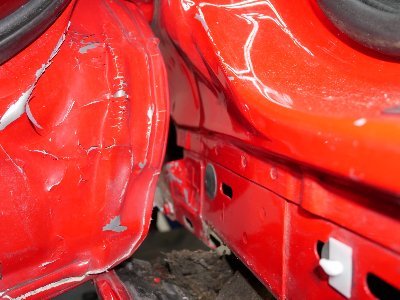 Vorderansicht eines roten Ford Kuga mit erkennbaren Unfallspuren an der Stoßstange und linken Seite