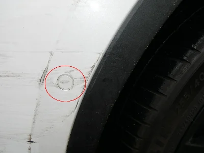 Frontansicht eines weißen Tesla Model S, der nach einem Unfall Schäden am linken vorderen Radhaus aufweist
