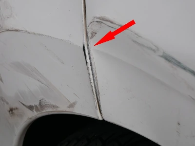 Ansicht der beschädigten hinteren rechten Seite eines weißen Peugeot 307 Cabrio auf einem Parkplatz