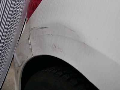 Weißes Peugeot 307 Cabrio zeigt Unfallspuren an der hinteren rechten Seite, inklusive zerkratzter Lack