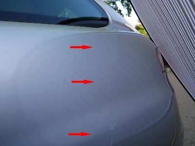 Ansicht der linken Fahrzeugseite eines silbernen Seat Ibiza mit Schäden durch eine zugeschlagene Autotür.