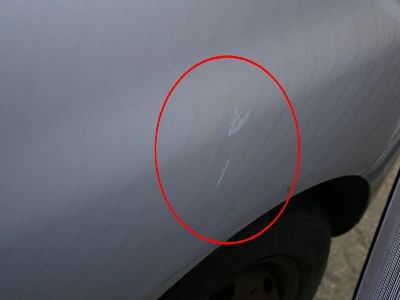 Silberner Seat Ibiza zeigt deutliche Dellen an der linken Seite, verursacht durch die Tür eines anderen Fahrzeugs
