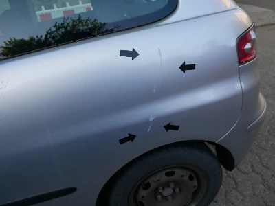 Seitenschaden am silbernen Seat Ibiza, fokussiert auf die durch eine Autotür verursachten Kratze