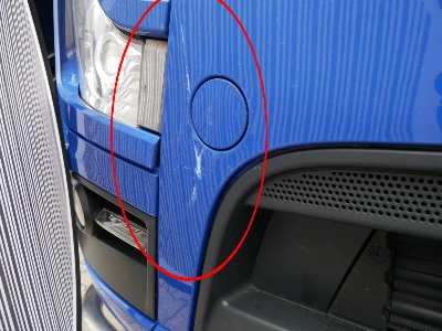 Frontansicht eines blauen Mercedes Actros nach einem leichten Unfall, mit Schwerpunkt auf Beschädigungen rechts