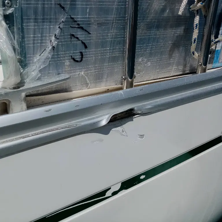 Bootsgutachter Wöllenweber untersucht einen Schaden an der Scheuerleiste sowie Bordwand eines Bootes nach einem Zusammenstoß